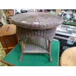 A circular topped wicker occasional table with under tier