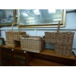 A pair of wicker stair baskets together with one other