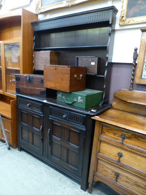 A mid-20th century dark oak dresser having plate rack to top,