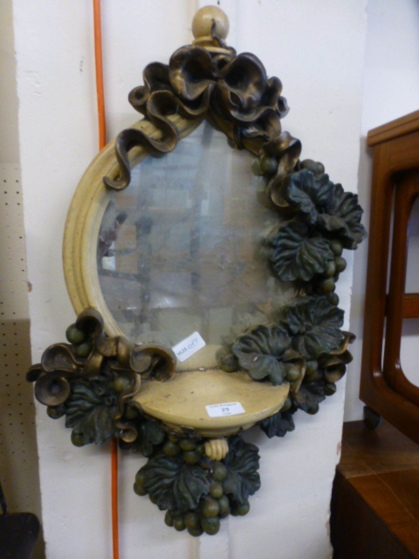 A moulded plaster mirror with vine design