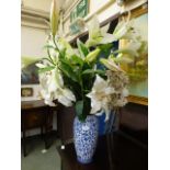 A blue and white ceramic vase together with a selection of artificial flowers