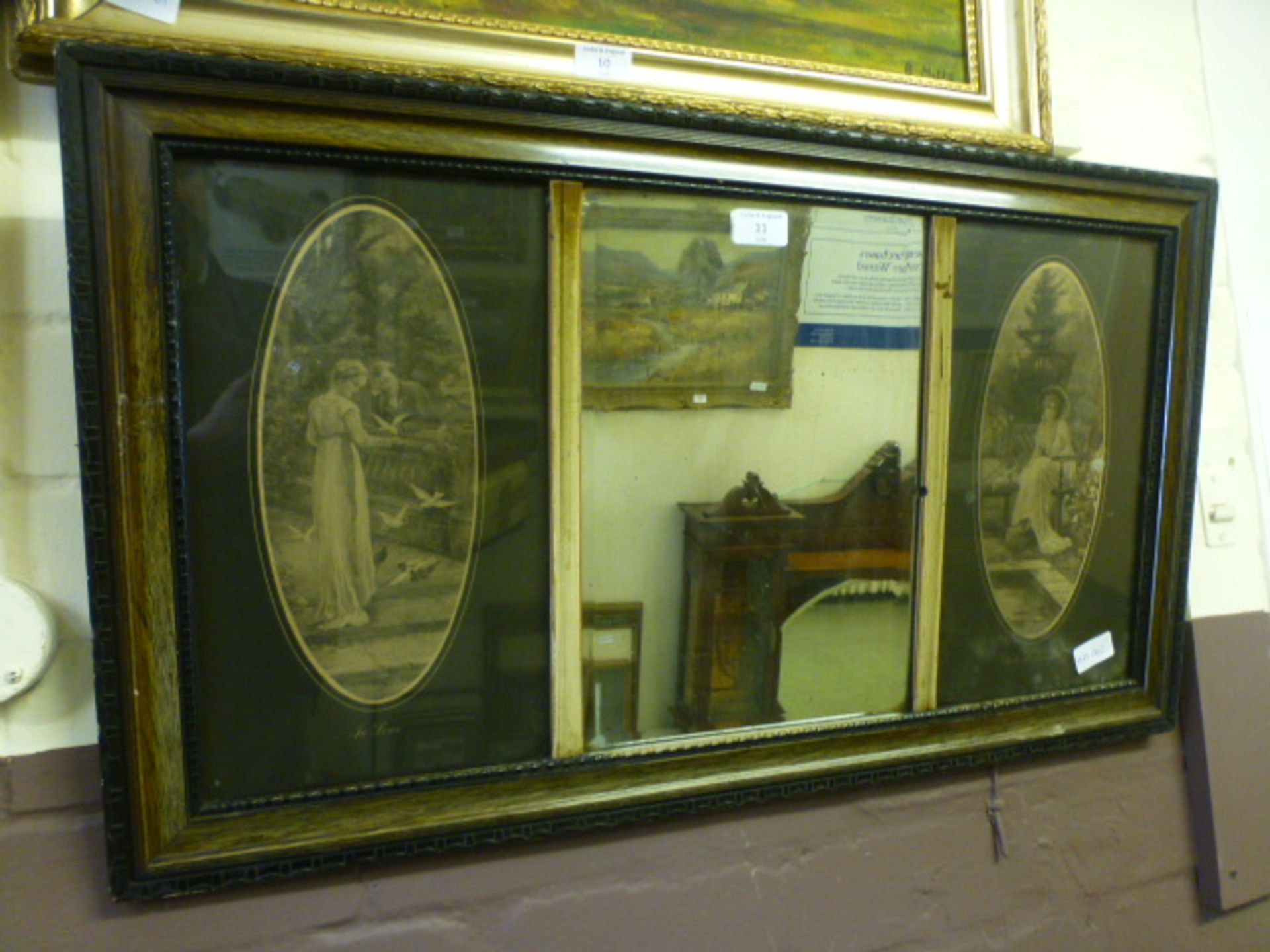 An early 20th century bevelled glass mirror with prints to side