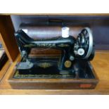 A dome cased Singer manual sewing machine