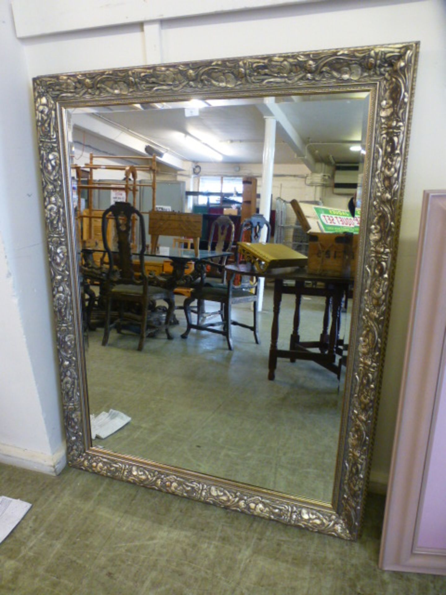 A large silver floral framed bevel glass mirror