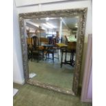 A large silver floral framed bevel glass mirror