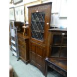 A mid 20th century full height corner cabinet having a leaded glazed door to top with cupboard