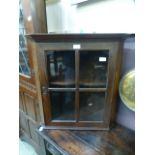 A small oak glazed corner wall mounted cupboard