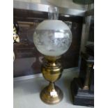 A brass oil lamp having an etched glass globular shade