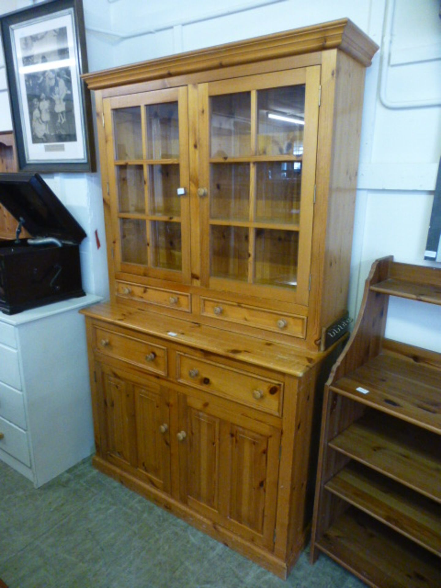 A modern pine dresser with glazed cupboard doors over drawers and cupboard doors