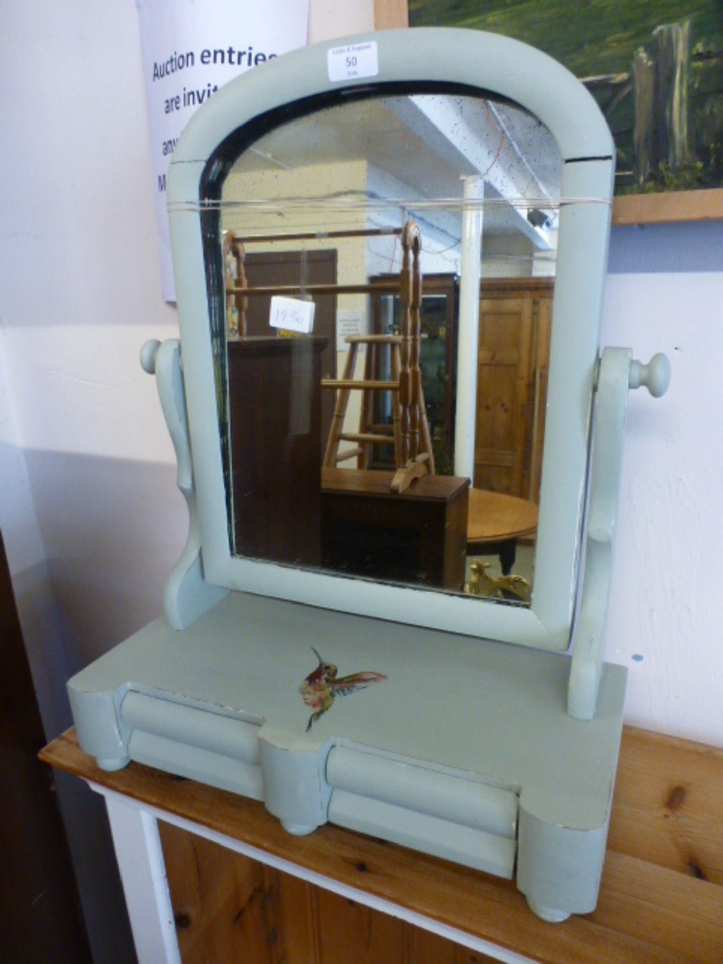 A green painted toilet mirror with humming bird design