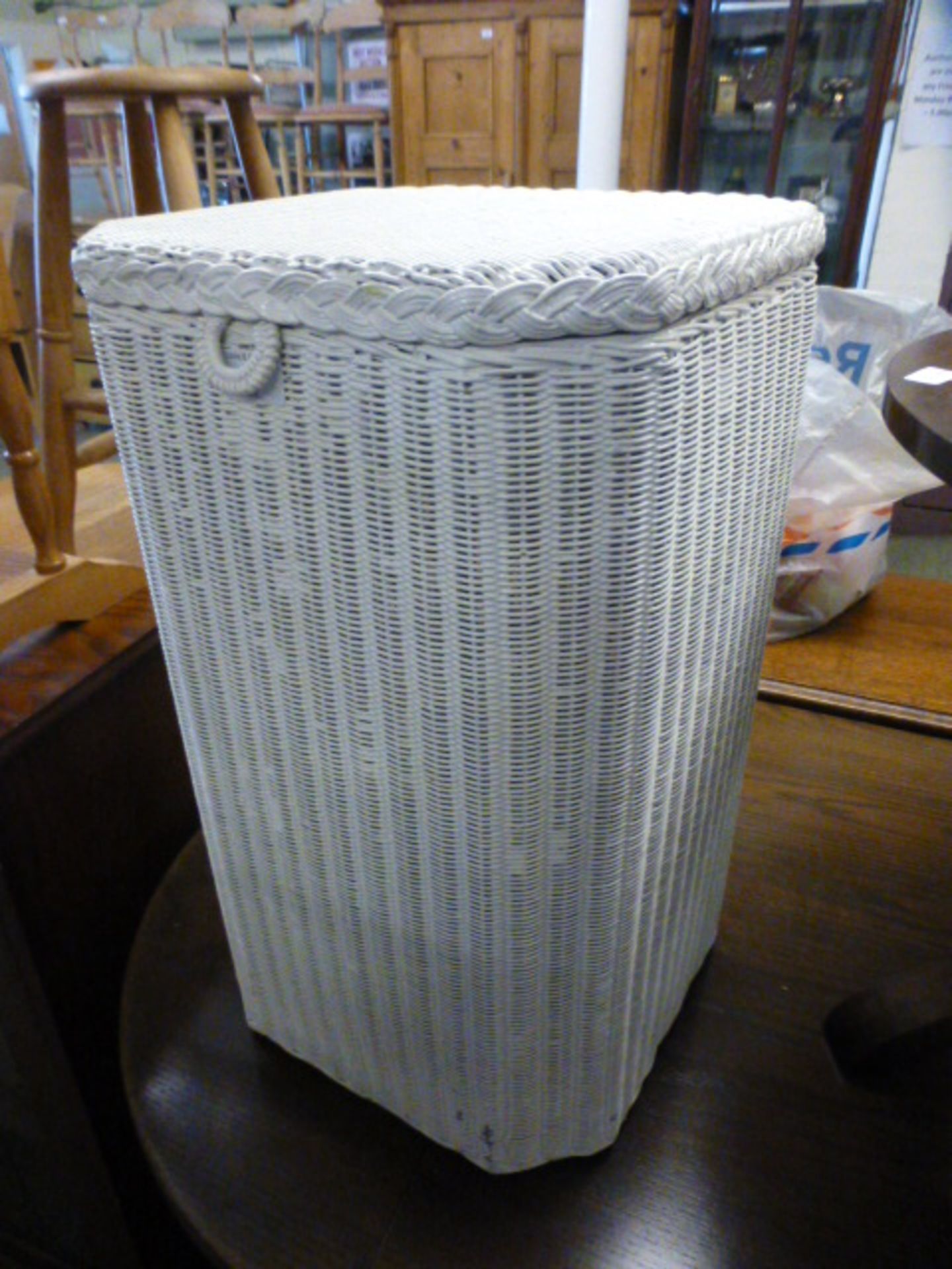 A cream painted wicker laundry basket