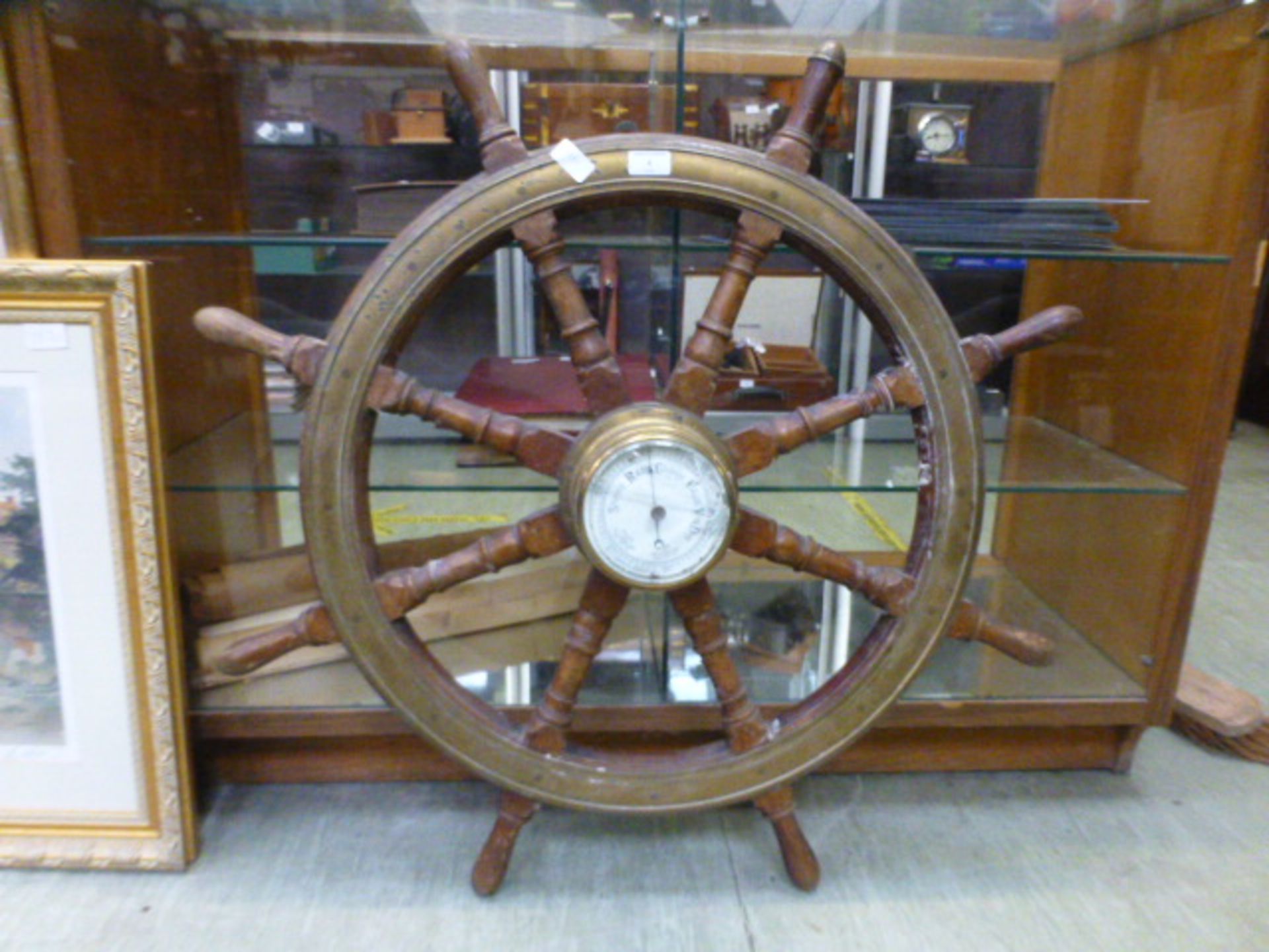 A barometer mounted on a ships wheel A/F