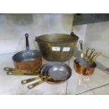 A selection of small copper saucepans together with a brass jam pan