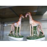 A pair of 19th century Staffordshire figures of greyhounds with hares