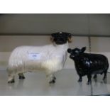 A ceramic model of a sheep together with a ceramic model of a cow