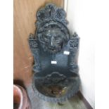 A cast iron garden fountain with lion mask spout