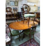 A reproduction mahogany pedestal table with centre leaf and a set of five similar balloon back