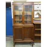 An early 20th century oak bookcase cabinet having a pair of leaded glazed doors to top,