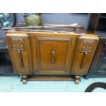 A mid-20th century oak veneered sideboard having a centre door concealing three drawers flanked by