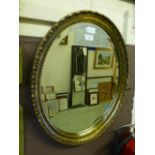 A mid-20th century oval gilt framed bevel glass wall mirror