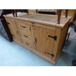 A modern pine dresser base having three drawers flanked by cupboard doors