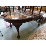 An early 20th century walnut piecrust edged wind-out dining table with one extra centre leaf