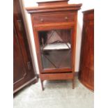 An early 20th century mahogany inlaid cabinet having a single drawer above glazed door with drawer