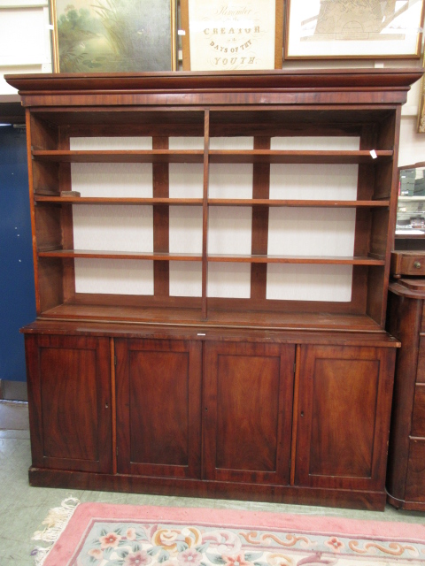 A Victorian and later mahogany bookcase having open storage above four cupboard doors