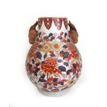 A 19th century Japanese imari vase, the body having floral decoration and animal head masks, h.