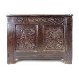 A late 17th century and later oak coffer, the later three panel top over a carved two panel front,