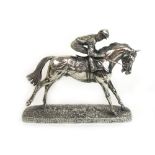 A silver filled model of a racehorse and jockey after David Geenty.