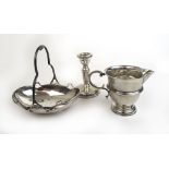 A George VI silver basket together with an Edwardian silver cream jug and a silver candle holder.