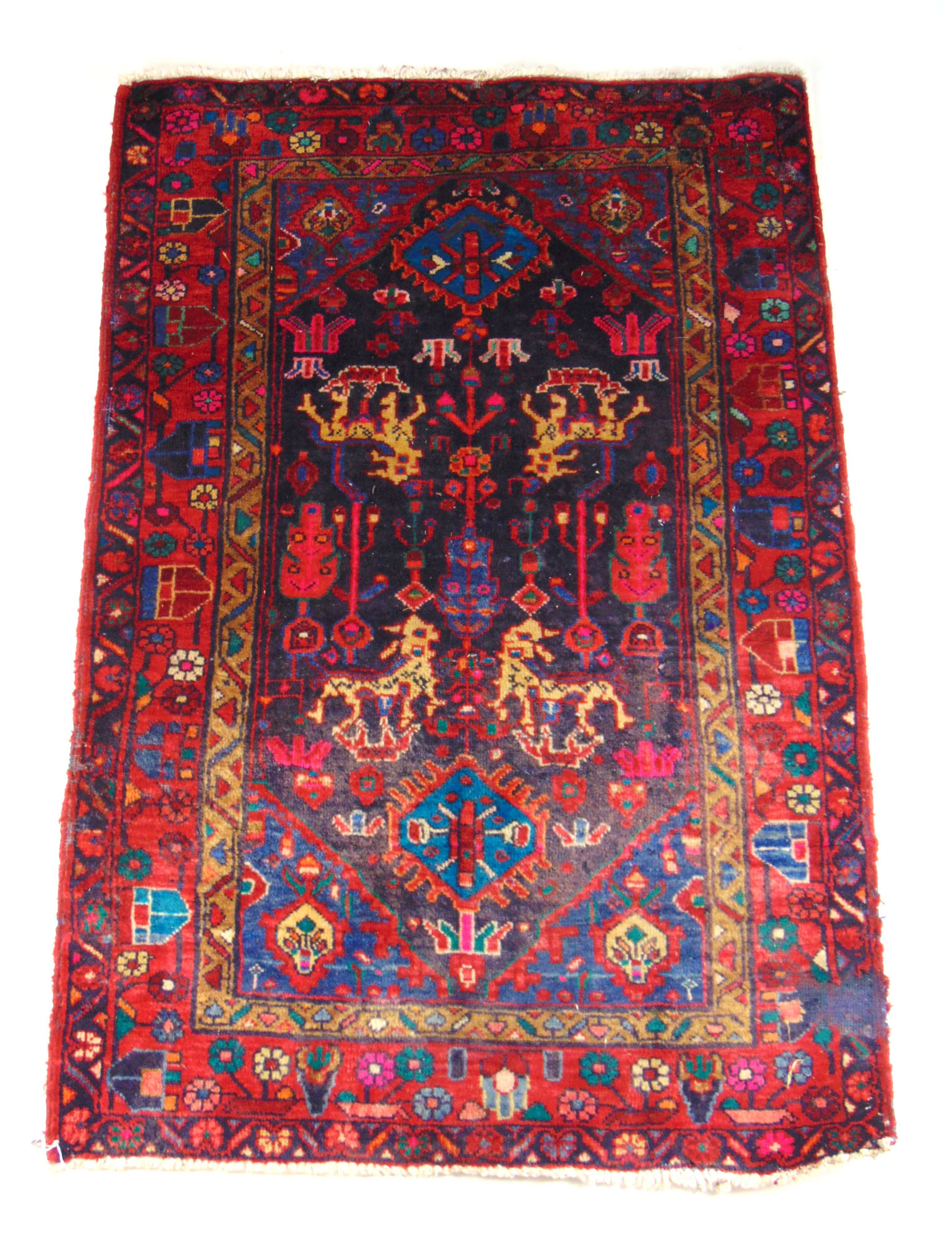 A handwoven Persian rug, the triple line border enclosing the field with animal motif's,