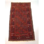 A handwoven Persian rug, the multi line border enclosing a geometrical field with spider motifs,