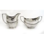 An Edwardian silver cream jug together with a matched George V silver sugar bowl. Various hallmarks.