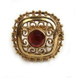 A yellow metal and red stone openwork ring stamped '585'. Approx weight 4.2g.