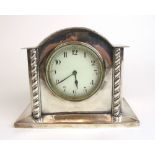 An Arts & Crafts silver plated mantle clock, the dial flanked by barley twist columns, h. 15.