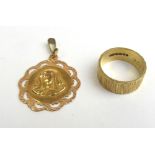 An 18ct gold textured band ring together with a yellow metal religious pendant. Approx weight 7.