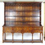 A reproduction 18th century style oak dresser, the plate rack over the base with four drawers,