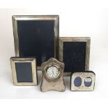 Four assorted silver photo frames together with one clock.