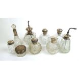 A collection of silver topped and collared cut glass scent bottles and atomizers.