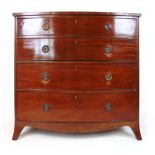 A late 18th century mahogany and boxwood strung bow front chest of four long drawers on splay feet,