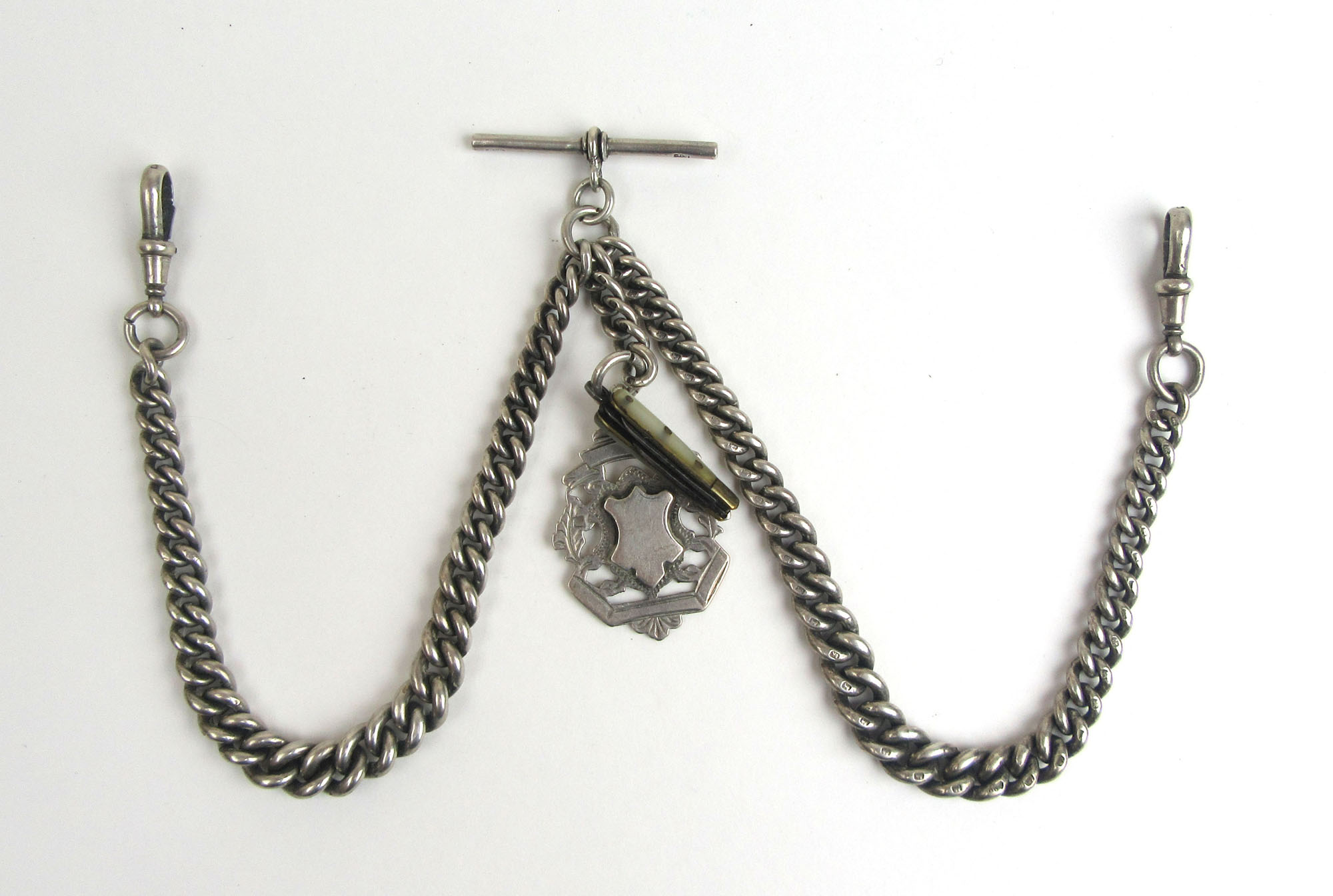 An early 20th century silver double Albert graduating pocket watch chain suspending a fob and