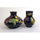 A Moorcroft 'Hibiscus' pattern vase of squat form together with one similar Moorcroft vase, h.