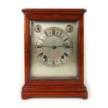 An early 20th century mahogany cased mantle clock with beveled glass top, sides and front,