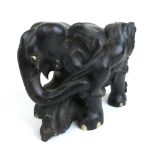 An early 20th century carved ebony model of an elephant fighting two lions, h.