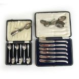 A cased set of silver spoons together with a cased set of silver handled butter knives and two sets
