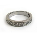A white metal and diamond half eternity ring, the nine stones in a channel setting.