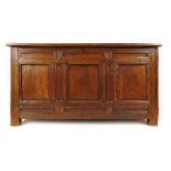 An early 18th century oak coffer, the four panel top over a three panel front, h. 72 cm, w.