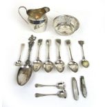 An assortment of silver and white metal items to include cream jug, pierced bowl, spoons,